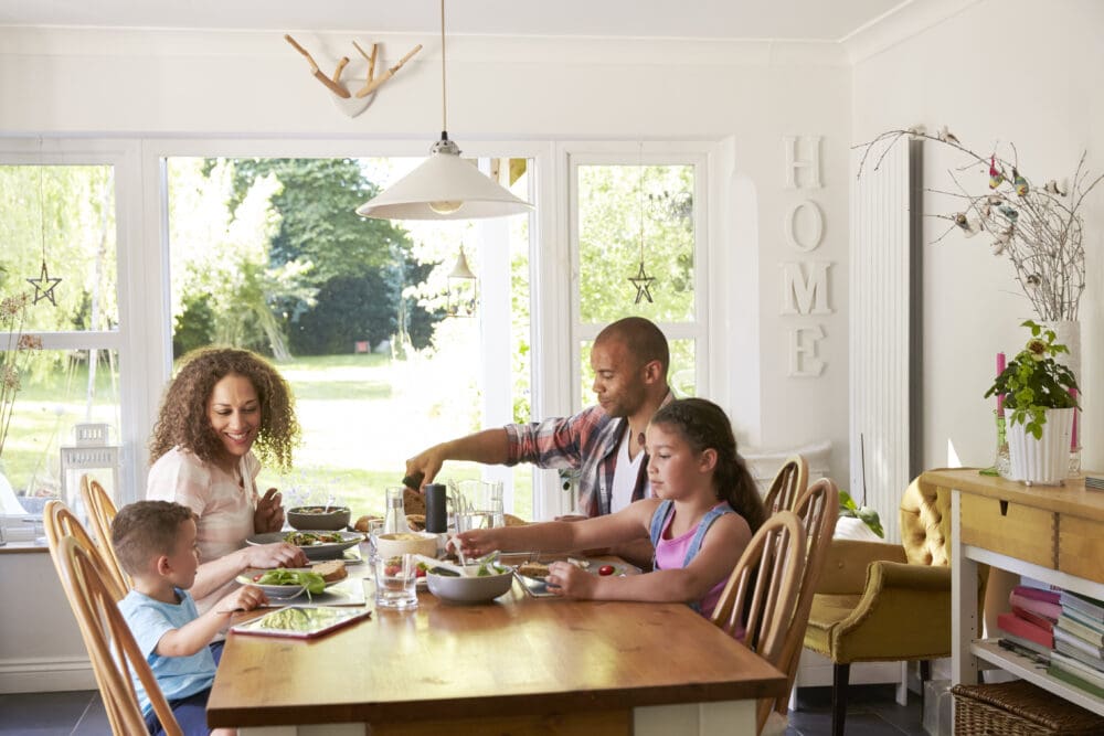 family at home eating meal in kitchen together
